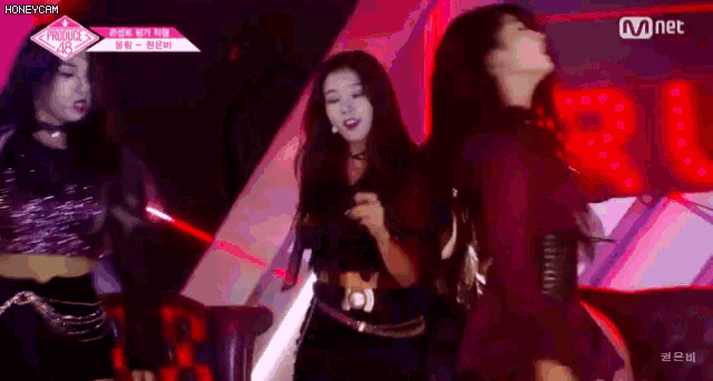 a group of girls are dancing in front of a mnet sign .