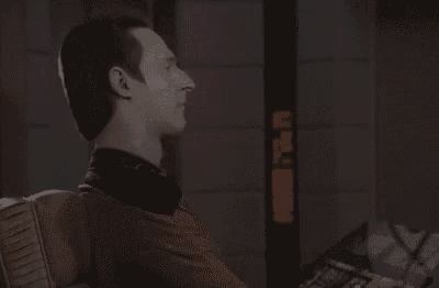 a man in a space suit is sitting in a chair in a dark room with smoke coming out of his mouth .