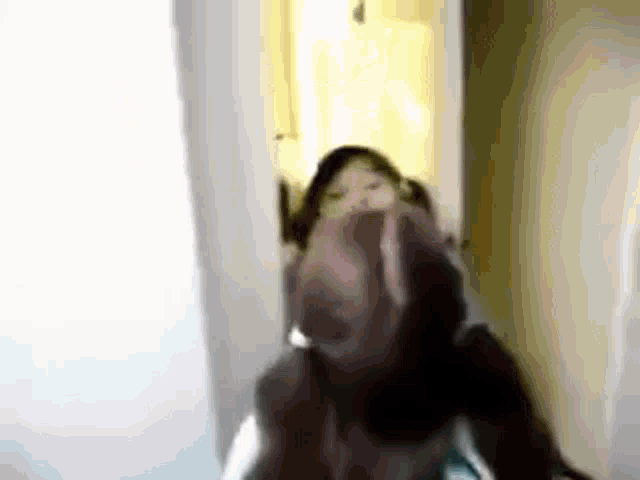 a blurry picture of a person making a funny face .
