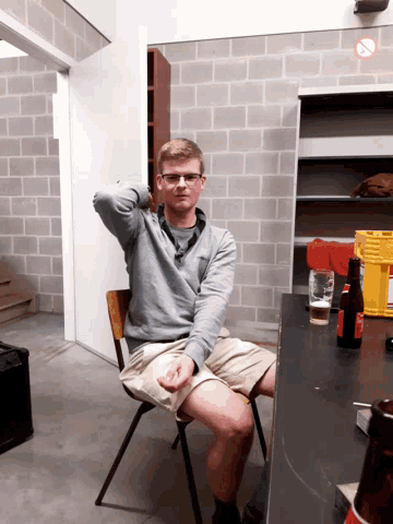 a man is sitting at a table with a no smoking sign on the wall behind him