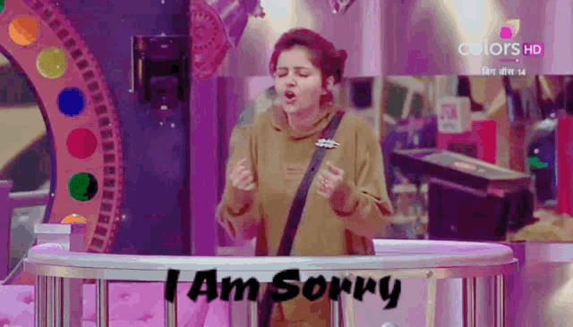 a woman stands in front of a sign that says " i am sorry "