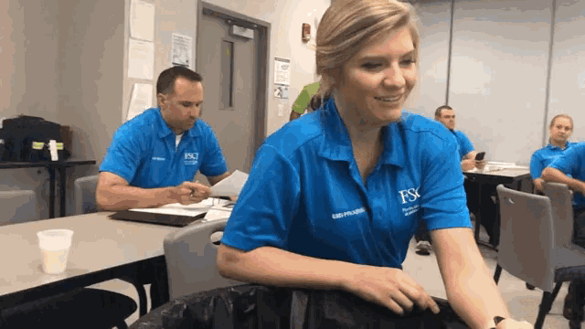 a woman wearing a blue shirt that says fsc on the front