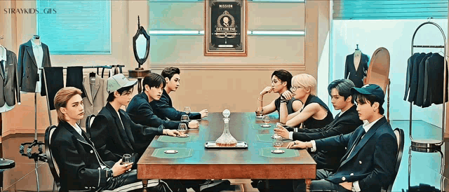 a group of young men are sitting around a table with a decanter on it