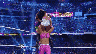two women are wrestling in a ring with a sign that says shine championship