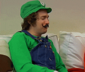 a man dressed as luigi from super mario is sitting on a couch with his eyes closed