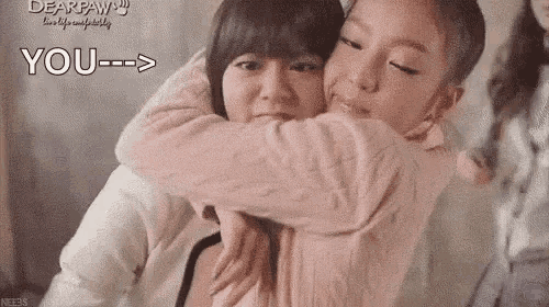 two women are hugging each other and one of them is holding the other 's arm .