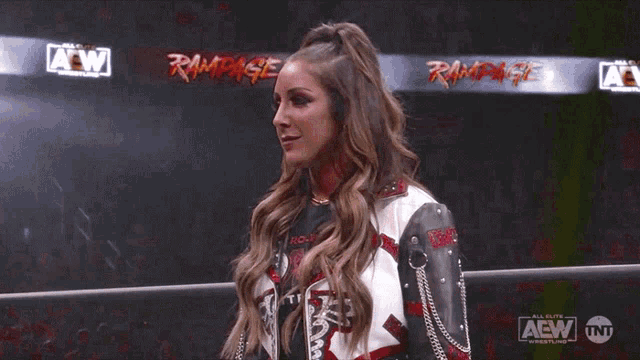 a woman is standing in a wrestling ring wearing a t-shirt that says rampage on it .