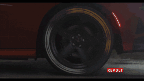 a couple standing under an umbrella in front of a car that says revolt on it