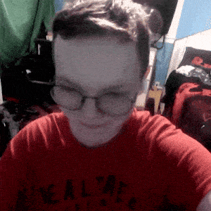 a person wearing glasses and a red shirt that says ' realtree ' on it
