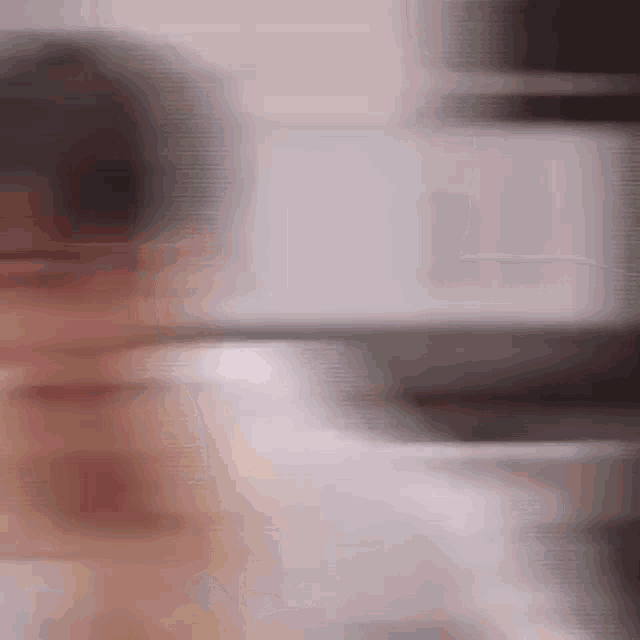 a blurry picture of a person standing in front of a computer .