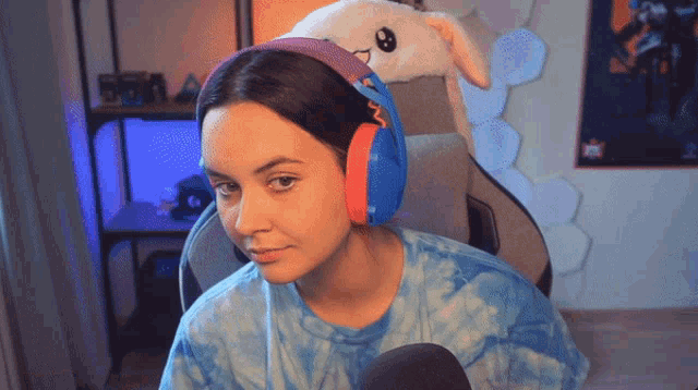 a woman wearing headphones and a stuffed bunny on her head