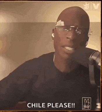 a man wearing glasses is sitting in front of a microphone .