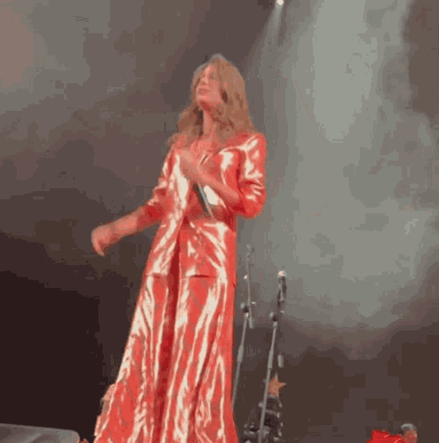 a woman in a red dress singing into a microphone