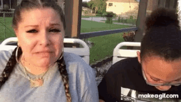 a woman is crying while sitting next to another woman on a boat .