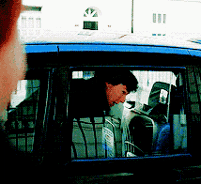 a man looks out of a car window with his head out