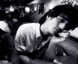 a man sitting at a table with his hand on his face