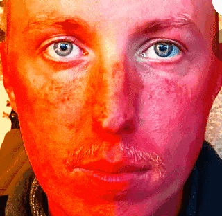 a close up of a man 's face with a blue eye