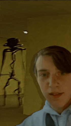 a man is standing in front of a spider statue