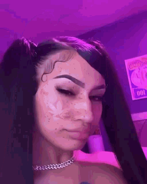 a girl with pigtails and a marijuana leaf on her face is looking at the camera .