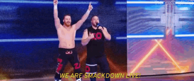 two wrestlers are standing on a stage with their arms in the air and they are smackdown live .