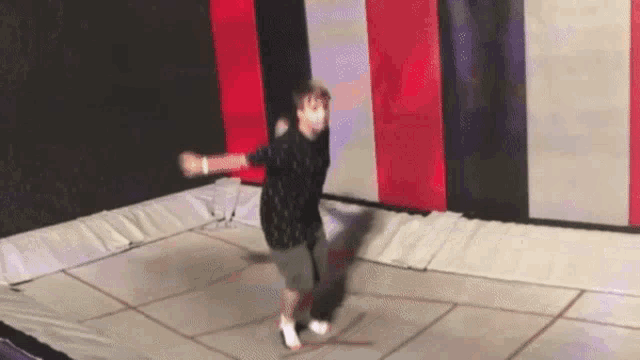 a person is jumping on a trampoline in a room .