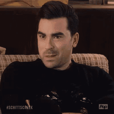a man is sitting on a couch with his eyes closed and making an okay sign .