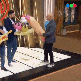 a group of men are standing on a stage holding balloons