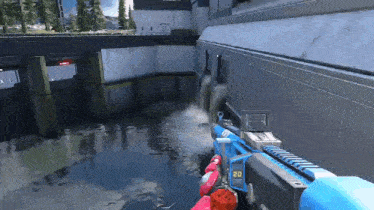 a person is holding a gun in a video game while standing in front of a body of water .