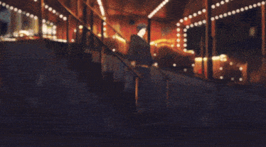 a man in a black jacket is standing on a set of stairs