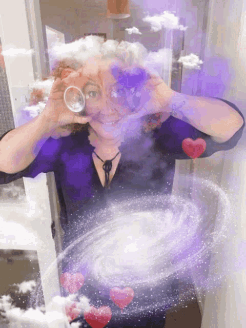a woman is making a heart shape with her hands while holding a glass