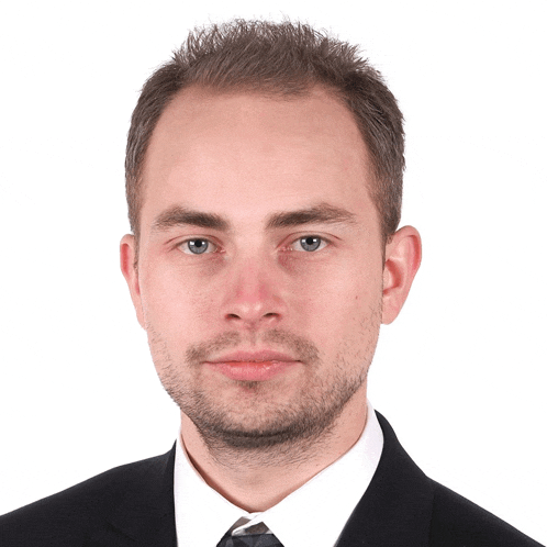 a man with a beard is wearing a black suit and tie