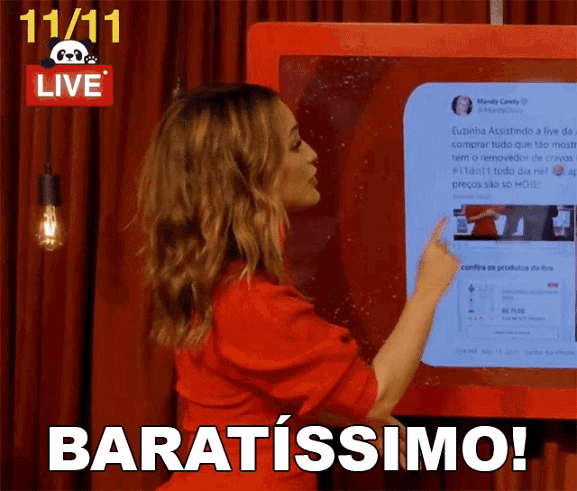 a woman in a red shirt is pointing at a screen that says baratissimo on it