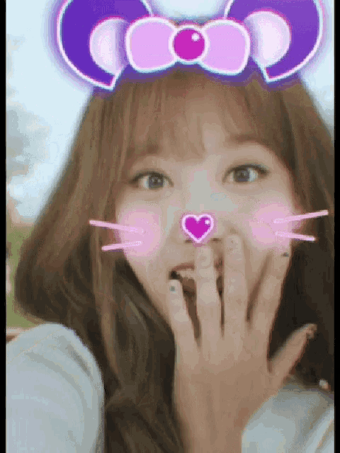 a girl with a purple bow on her head has a heart in her nose