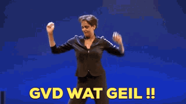 a woman in a suit is dancing on a stage with the words gvd wat geil written in yellow .