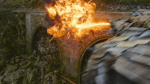 a bridge with a large explosion in the background