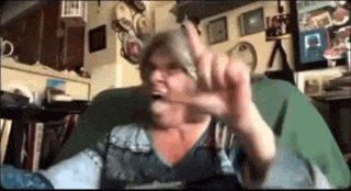 a woman is sitting in a chair with her mouth open and making a funny face .