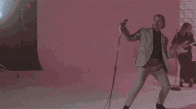 a man in a suit singing into a microphone with the words " give you all i got " below him
