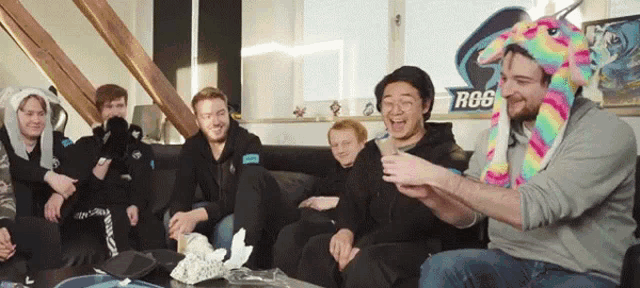a group of people sit on a couch in front of a sign that says rg6
