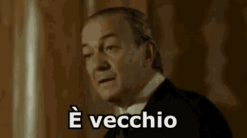 a man in a suit and tie is saying `` ha fatto il suo tempo '' in italian .