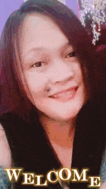 a woman with a tattoo on her face is smiling and the word welcome is on the bottom