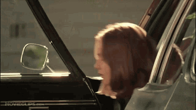 a woman getting out of a car with movieclips.com written on the side of the car