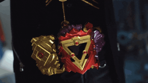 a close up of a person holding a red and gold object
