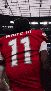 a football player wearing a red jersey with the number 11 on it