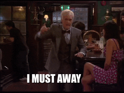 a man in a suit is dancing in a bar while a woman sits at a table and says i must away .