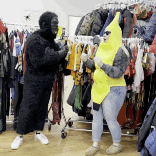 a man dressed as a gorilla and a woman dressed as a banana are standing in front of clothes racks