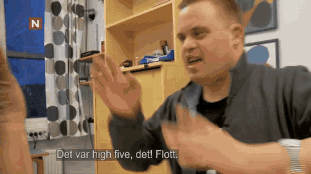 a man is giving a high five to another man and the words det var high five det flott are visible