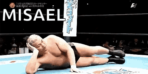 a man is laying on the ground in a wrestling ring with the word misael behind him