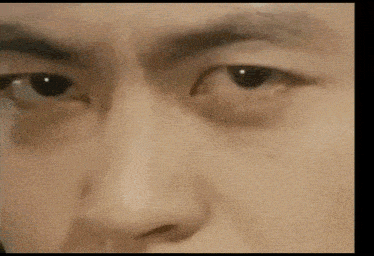 a close up of a man 's face with his eyes looking at the camera .