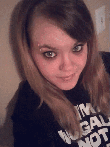 a woman wearing a black shirt that says i 'm legal not illegal