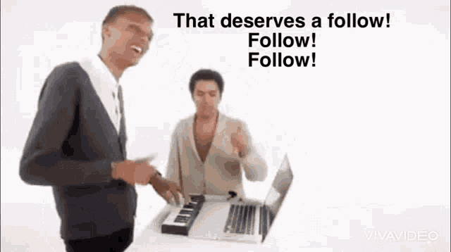 two men are standing next to each other in front of a laptop and a keyboard .